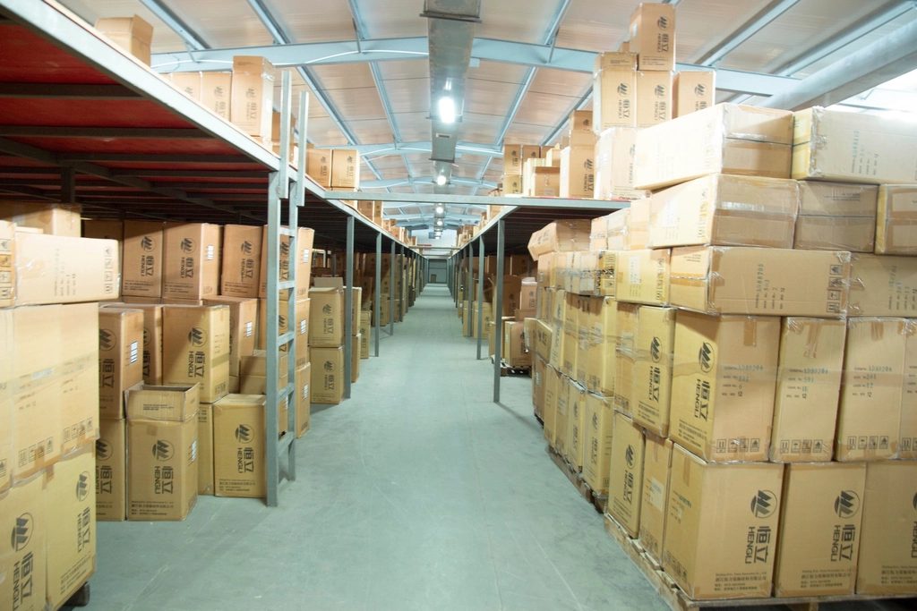 Long warehouse aisle stacked high with boxed product on both sides